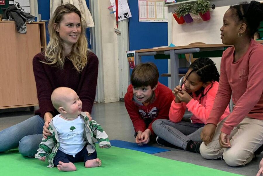 Roots of Empathy students engaging with their Tiny Teacher on the green blanket